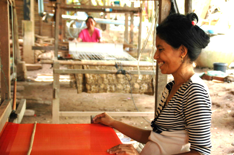 Cambodian artisan is weaving a silk scarf