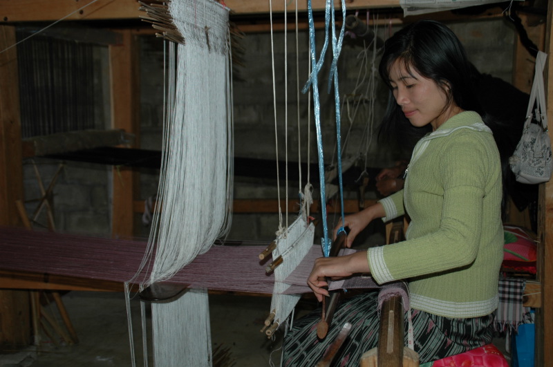 Lao artisan is weaving a complex silk scarf
