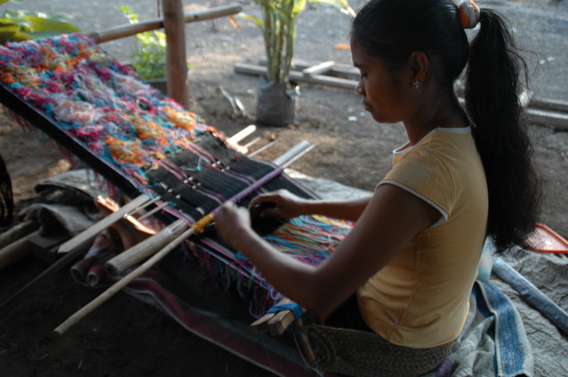 Artisan is weaving a silk scarf in the complex buna technique