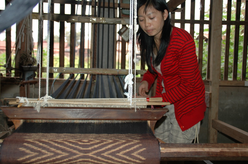 Artisan at Phontong is weaving a teak pattern silk scarf