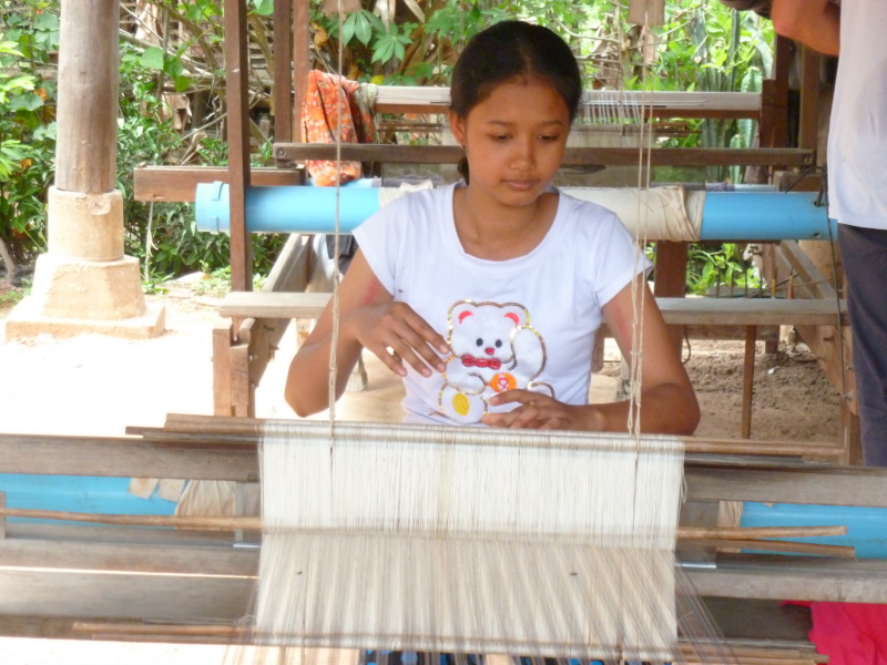 Woman artisan is weaving a silk scarf