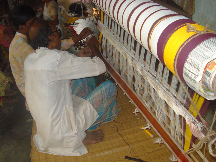 Artisans working on cotton shawls in India
